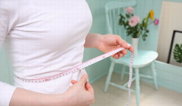 ウエストサイズを測る女性の画像